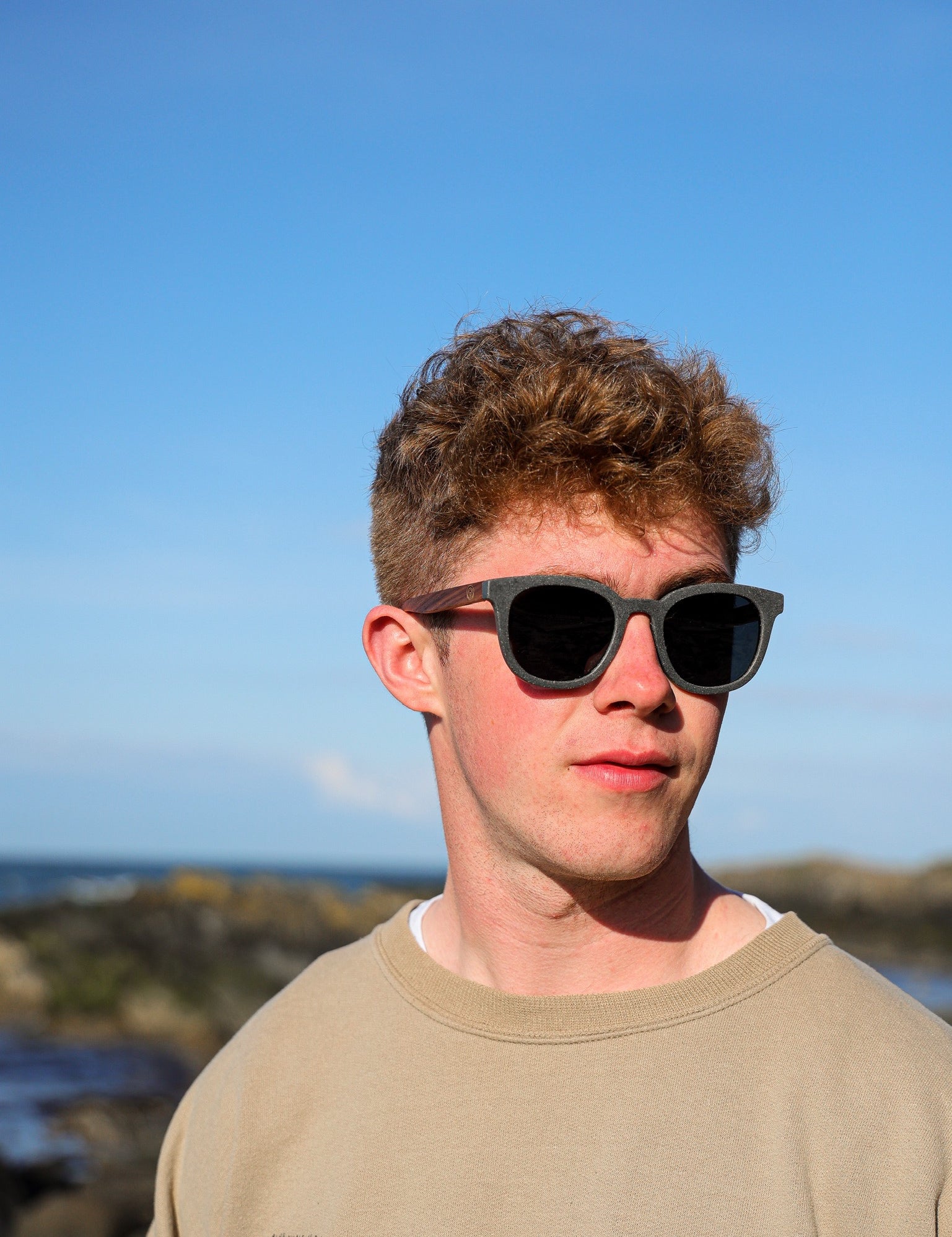 Made with sustainable speckled charcoal wheat straw or coffee residue frame and walnut wood temples, these stylish shades are lightweight, comfortable and eco-friendly with their plastic alternative materials. Fitted with UV400 polarised lenses in a smoke black colour and subtle logo is engraved on the temples. Sunglasses come with a padded pouch and microfibre cleaning cloth.