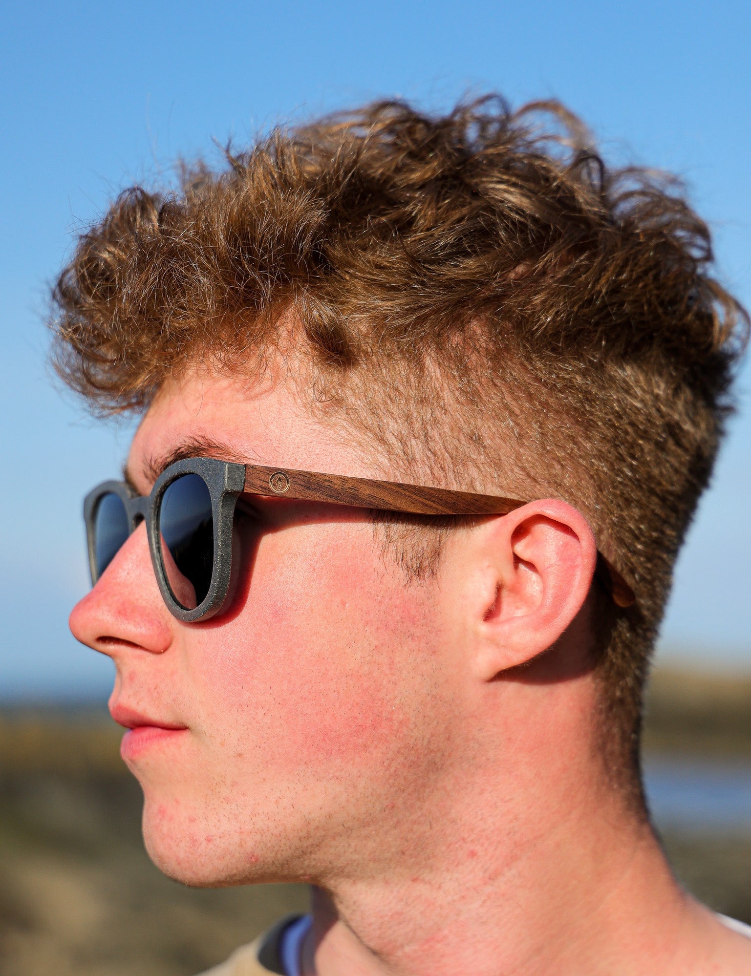 Made with sustainable speckled charcoal wheat straw or coffee residue frame and walnut wood temples, these stylish shades are lightweight, comfortable and eco-friendly with their plastic alternative materials. Fitted with UV400 polarised lenses in a smoke black colour and subtle logo is engraved on the temples. Sunglasses come with a padded pouch and microfibre cleaning cloth.