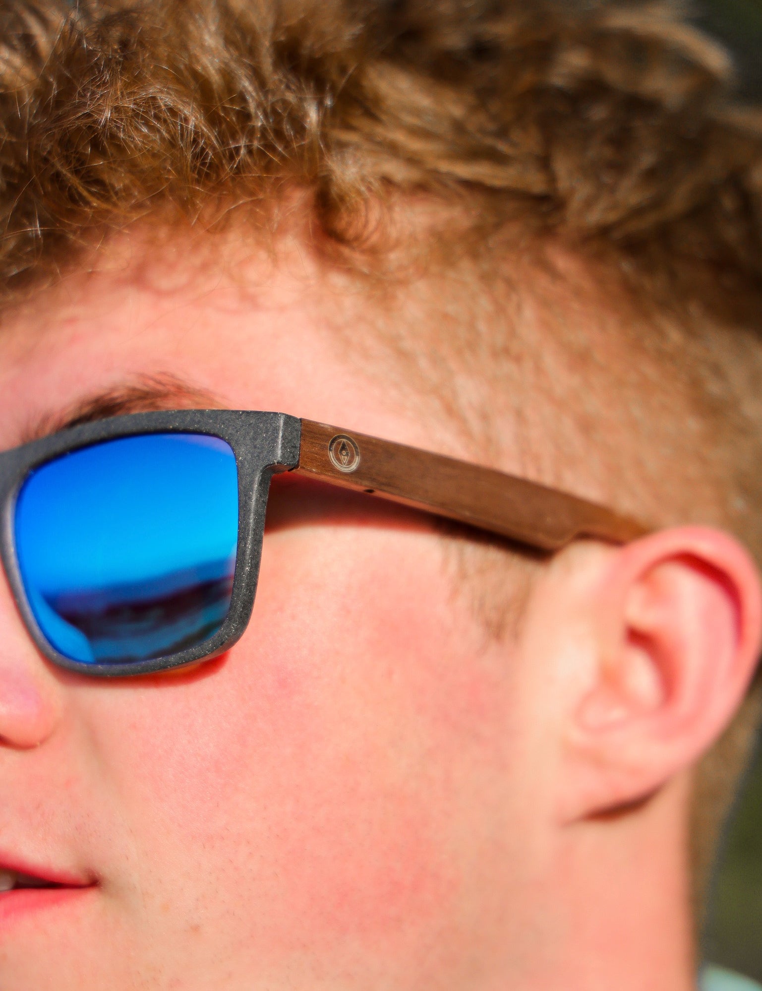 This sustainable rectangular frame is made with a speckled charcoal wheatstraw frame and walnut wood temple and is fitted with UV400 polarised lenses in two colours, smoke and mirrored sky blue. It's lightweight, comfortable and eco-friendly using plastic alternative materials.