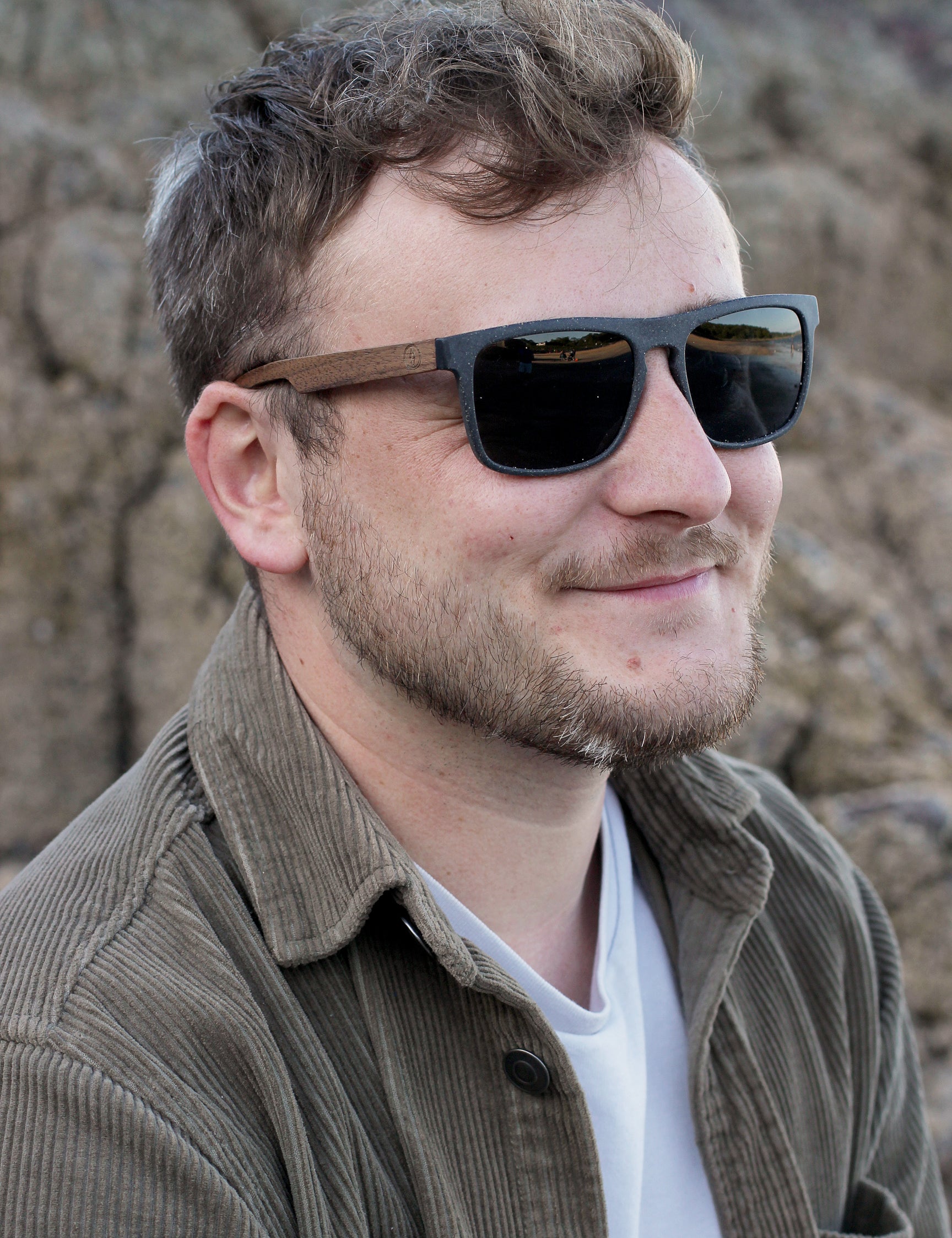 This sustainable rectangular frame is made with a speckled charcoal wheatstraw frame and walnut wood temple and is fitted with UV400 polarised lenses in two colours, smoke and mirrored sky blue. It's lightweight, comfortable and eco-friendly using plastic alternative materials.