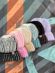Set of colorful knit hats on a patterned background