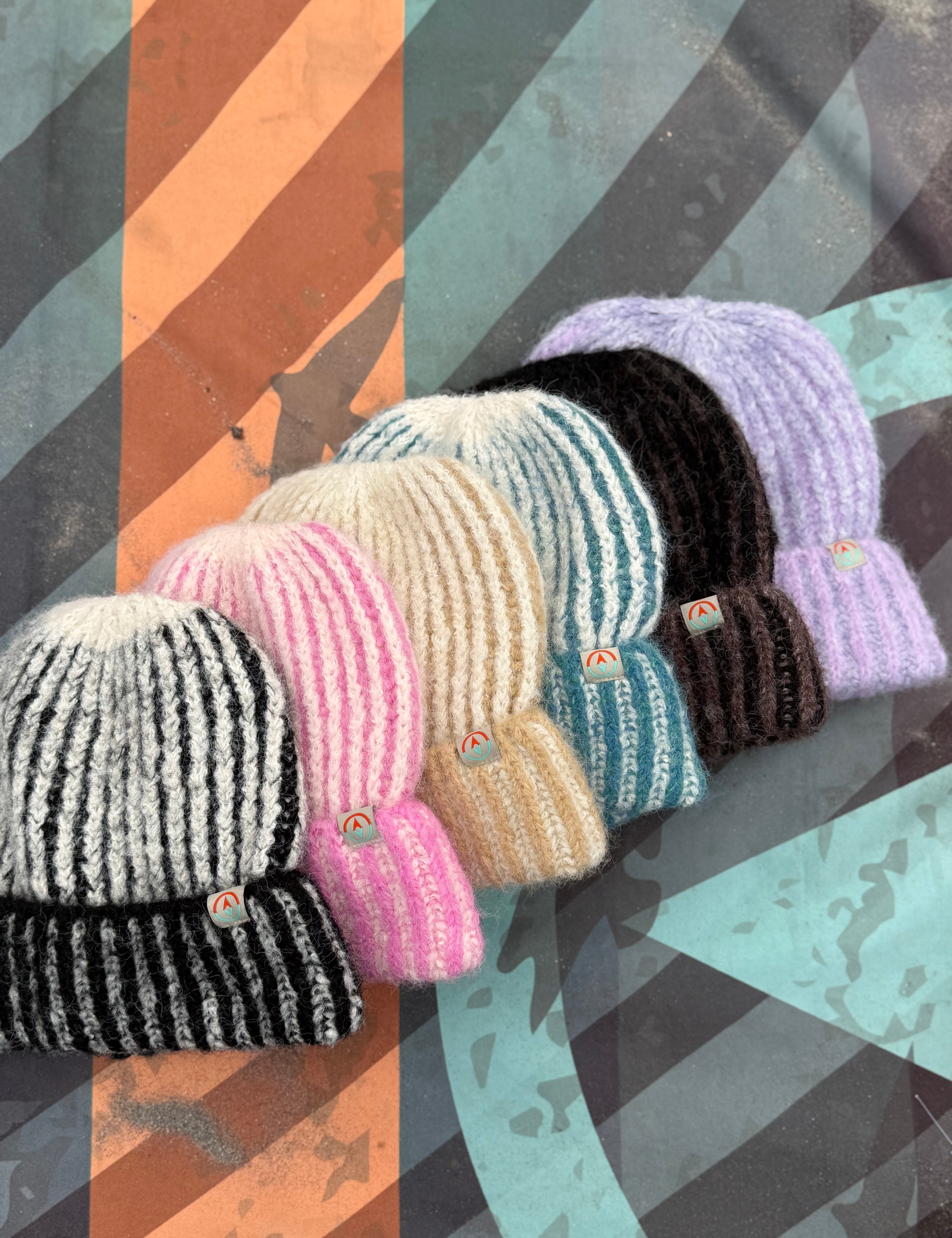Set of colorful knit hats on a patterned background