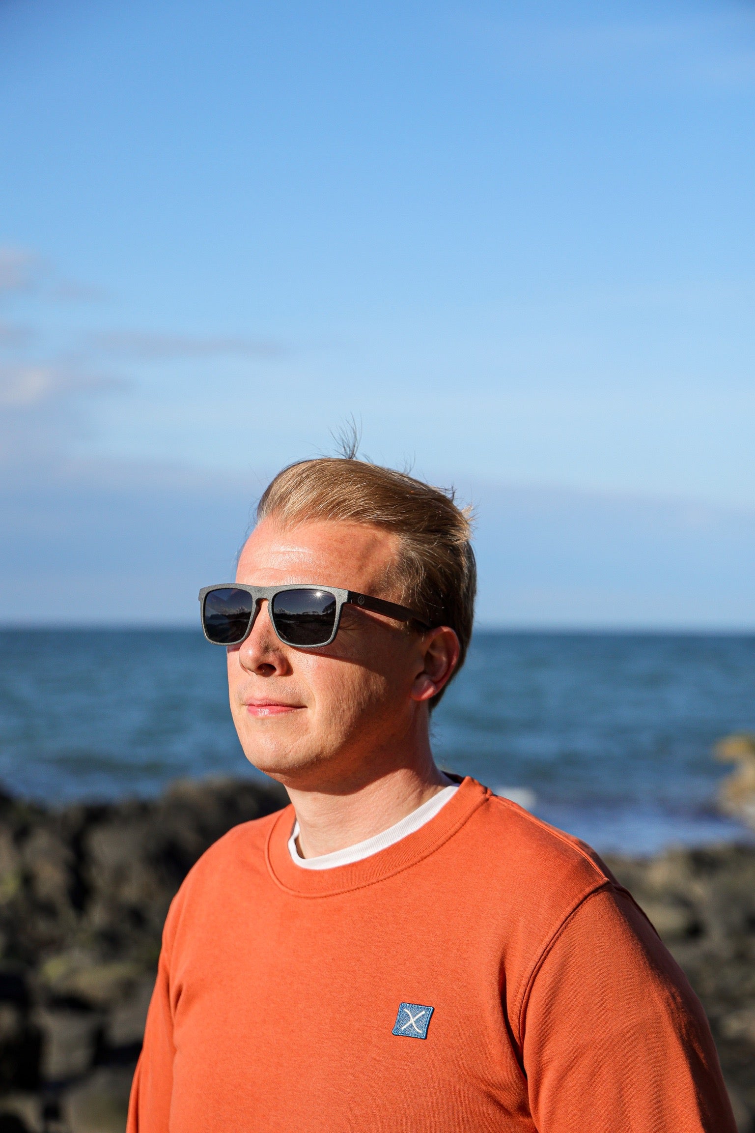 This sustainable rectangular frame is made with a speckled charcoal wheatstraw frame and walnut wood temple and is fitted with UV400 polarised lenses in two colours, smoke and mirrored sky blue. It's lightweight, comfortable and eco-friendly using plastic alternative materials. 