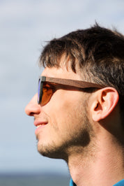 A classic soft rectangular frame. Made with a sustainable speckled charcoal wheatstraw or coffee residue frame and walnut wood temples, it's lightweight and comfortable offering the highest protection with UV400 polarised lenses in a smoke black colour or mirror sky blue. Eco-friendly using plastic alternative frames t…