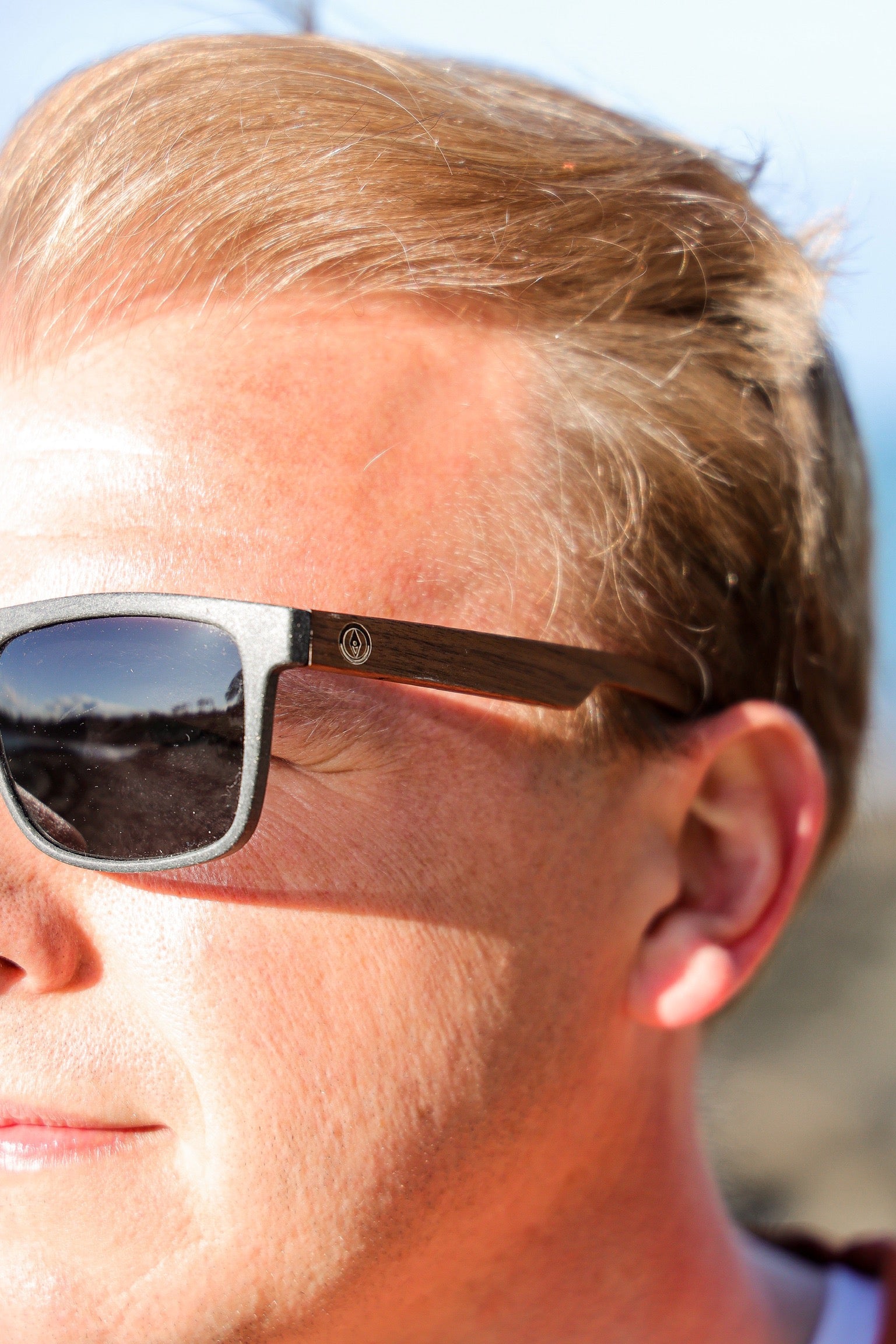 This sustainable rectangular frame is made with a speckled charcoal wheatstraw frame and walnut wood temple and is fitted with UV400 polarised lenses in two colours, smoke and mirrored sky blue. It's lightweight, comfortable and eco-friendly using plastic alternative materials. 