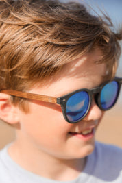 Made with a sustainable speckled wheatstraw frame with walnut wood temples, it's lightweight and comfortable. Fitted with UV400 polarised lenses. Our large child/teen/small adult frame and provides a neater fit without compromising on eye protection.