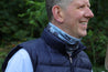 Man wearing the multiway Infinity Band around his neck outdoors in a forest showing its grey and black design inspired by The Giants Causeway in Northern Ireland.