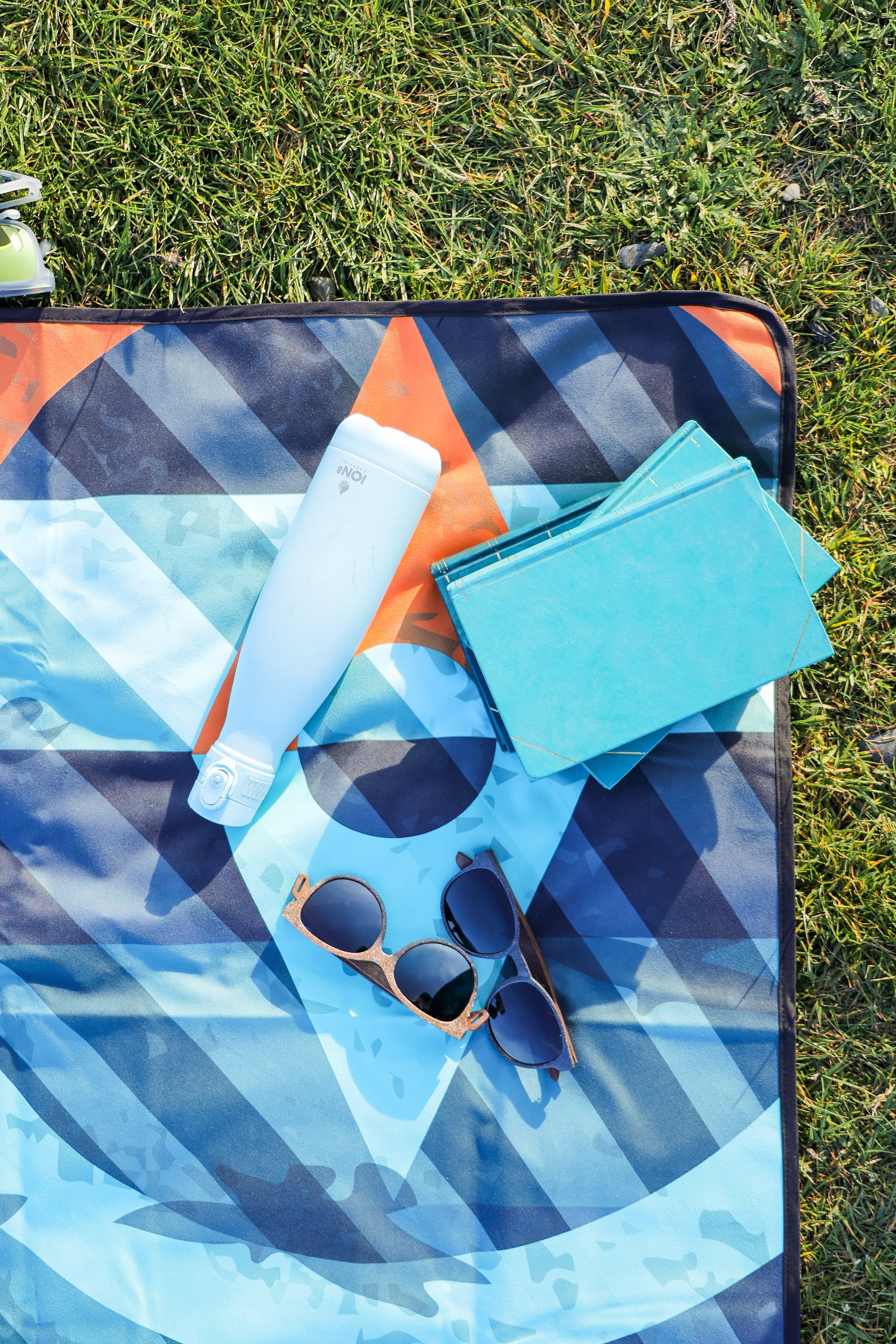 Sustainable waterproof picnic blanket made from recycled polyester, oversized yet packable as it folds flat into a laptop size to slide into a backpack. Zip corner pocket and stake loops and sand pockets to keep it in place. 