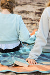 Sustainable waterproof picnic blanket made from recycled polyester, oversized yet packable as it folds flat into a laptop size to slide into a backpack. Zip corner pocket and stake loops and sand pockets to keep it in place. 