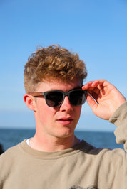 A classic soft rectangular frame. Made with a sustainable speckled charcoal wheatstraw or coffee residue frame and walnut wood temples, it's lightweight and comfortable offering the highest protection with UV400 polarised lenses in a smoke black colour or mirror sky blue. Eco-friendly using plastic alternative frames t…