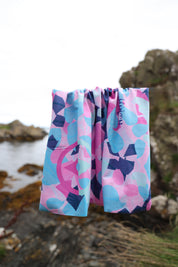 Cerise, soft pink, turquoise, mint and navy Infinity Band or snood hanging before rocks outdoors displaying the colours and terrazzo pattern.