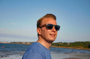 This sustainable rectangular frame is made with a speckled charcoal wheatstraw frame and walnut wood temple and is fitted with UV400 polarised lenses in two colours, smoke and mirrored sky blue. It's lightweight, comfortable and eco-friendly using plastic alternative materials. 
