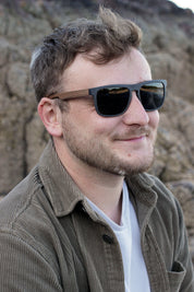This sustainable rectangular frame is made with a speckled charcoal wheatstraw frame and walnut wood temple and is fitted with UV400 polarised lenses in two colours, smoke and mirrored sky blue. It's lightweight, comfortable and eco-friendly using plastic alternative materials. 