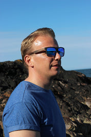 This sustainable rectangular frame is made with a speckled charcoal wheatstraw frame and walnut wood temple and is fitted with UV400 polarised lenses in two colours, smoke and mirrored sky blue. It's lightweight, comfortable and eco-friendly using plastic alternative materials. 